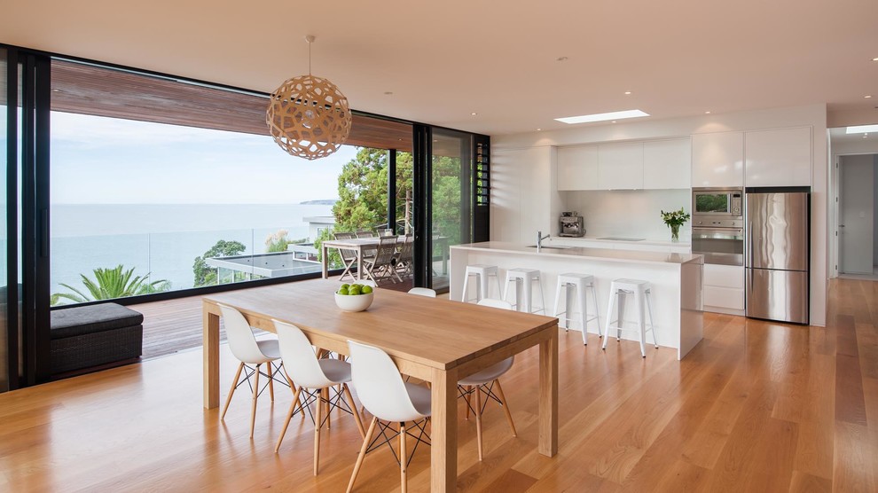 This is an example of a contemporary kitchen/dining combo in Auckland with medium hardwood floors and brown floor.