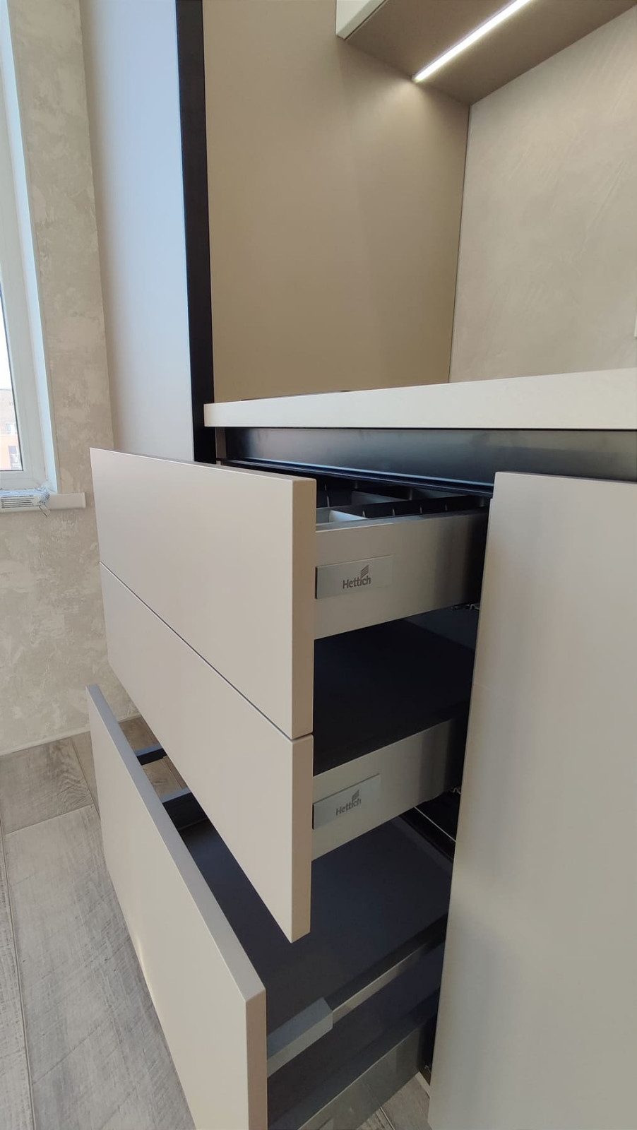 Небольшая встроенная кухня в серо-белом цвете с однотонными фасадами