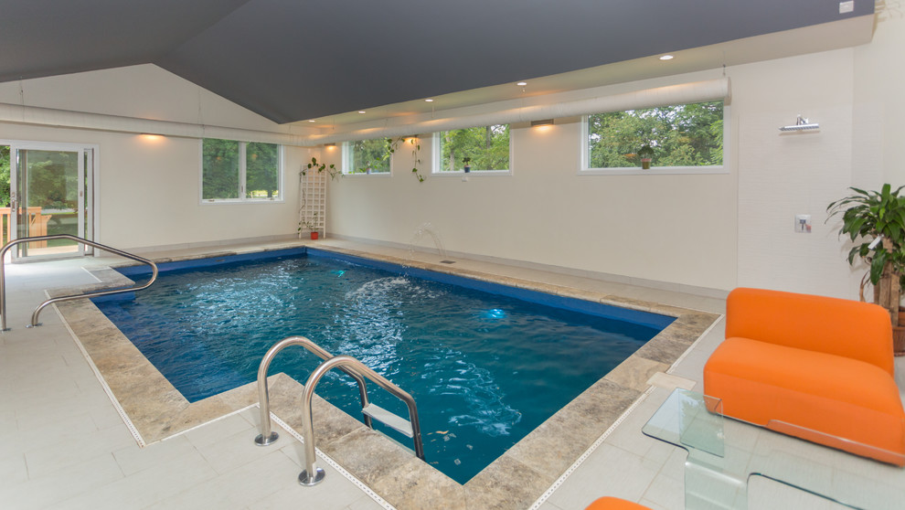 This is an example of an expansive contemporary indoor rectangular lap pool in Philadelphia with a water feature and tile.