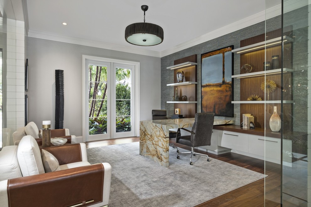 Design ideas for an expansive contemporary study room in Miami with grey walls, a built-in desk, medium hardwood floors and brown floor.