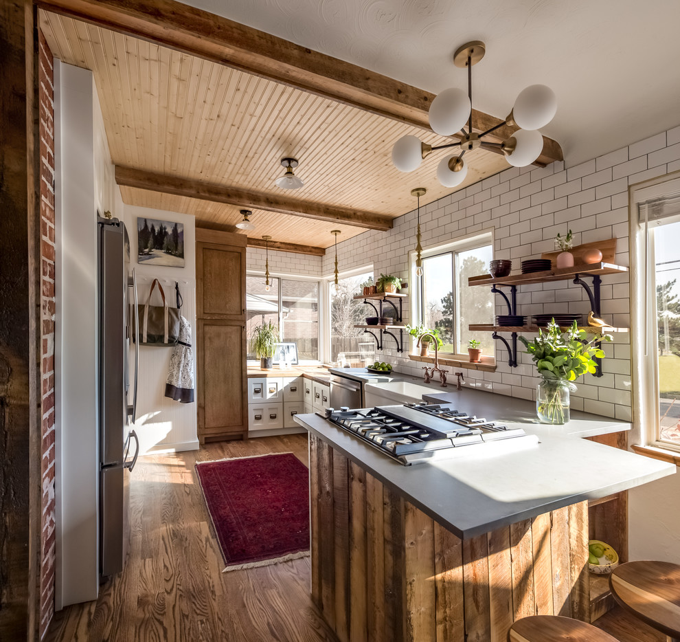 Inspiration for a small country u-shaped separate kitchen in Denver with a farmhouse sink, shaker cabinets, wood benchtops, white splashback, ceramic splashback, stainless steel appliances, dark hardwood floors, a peninsula, multi-coloured benchtop, brown floor and timber.