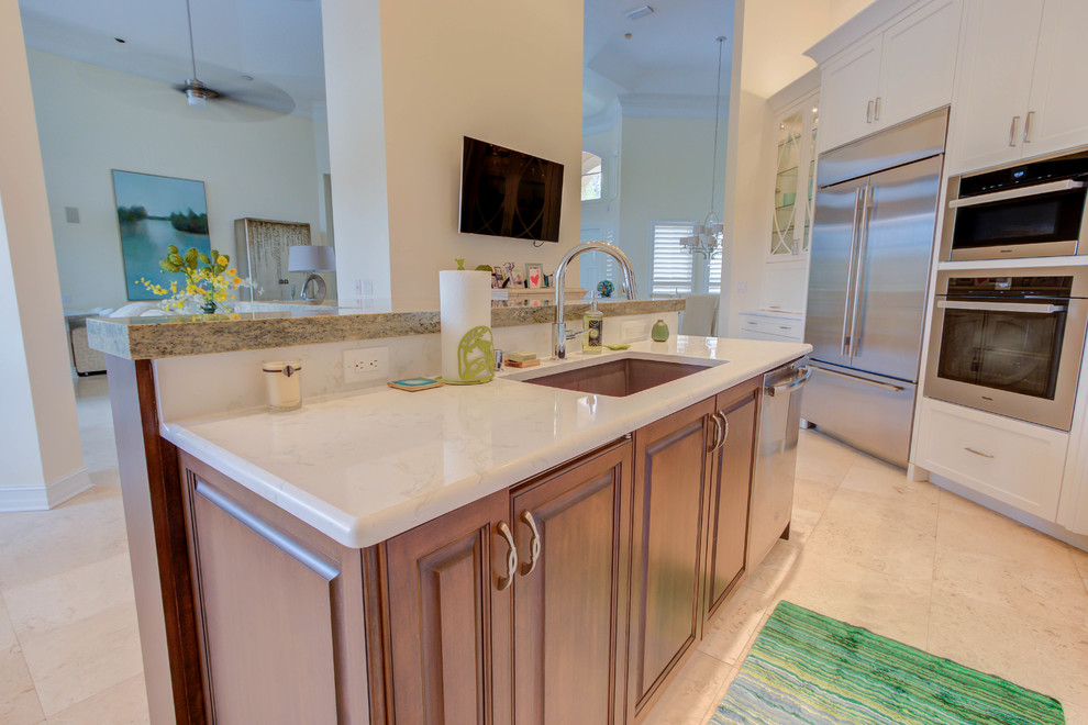 Large transitional single-wall enclosed kitchen photo with an undermount sink, flat-panel cabinets, white cabinets, quartz countertops, blue backsplash, stone tile backsplash, stainless steel appliances and an island