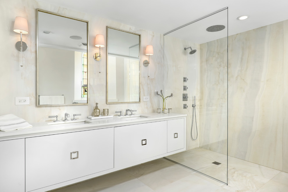 This is an example of a contemporary bathroom in Chicago with an undermount sink, flat-panel cabinets, white cabinets, an open shower, beige tile, stone slab, beige floor and an open shower.