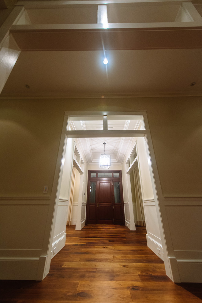 Entry hall - mid-sized transitional medium tone wood floor and beige floor entry hall idea in Miami with white walls and a dark wood front door