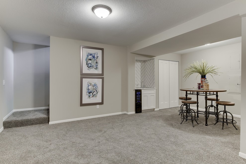 Mid-sized transitional fully buried basement in Minneapolis with grey walls, carpet and grey floor.