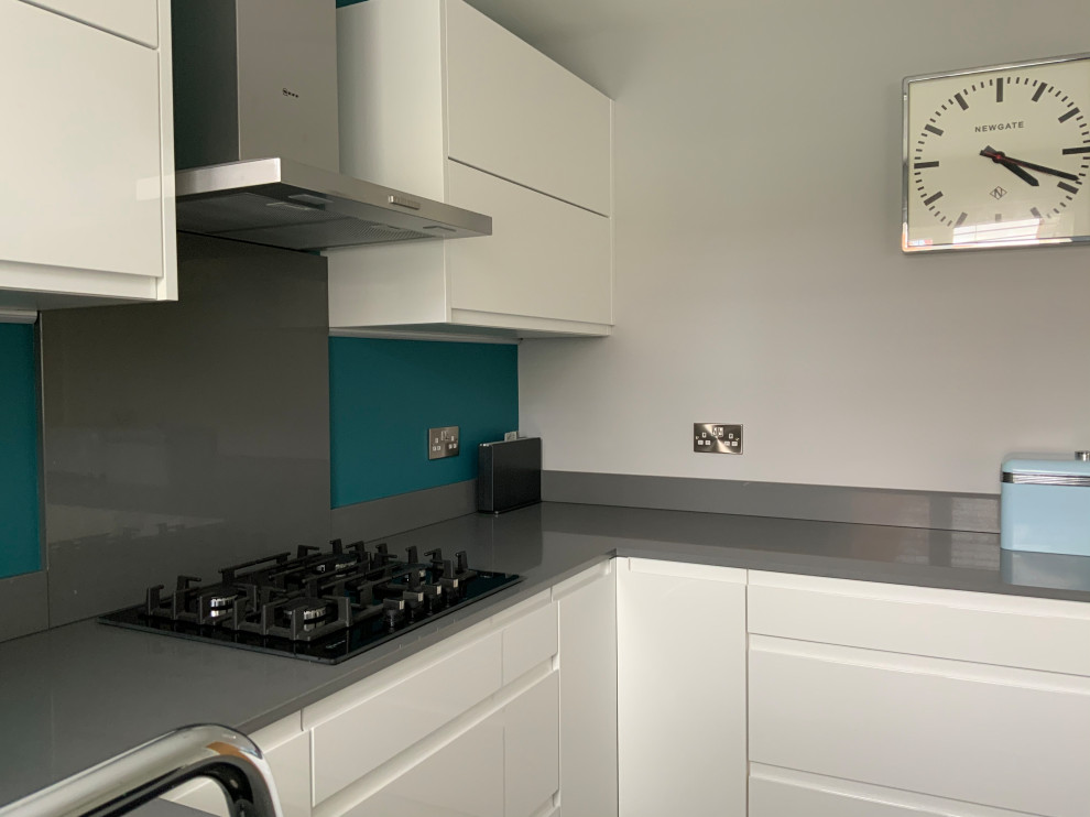 Design ideas for a medium sized contemporary u-shaped kitchen in Buckinghamshire with flat-panel cabinets, white cabinets, quartz worktops, grey splashback, engineered quartz splashback, integrated appliances, no island, grey floors and grey worktops.