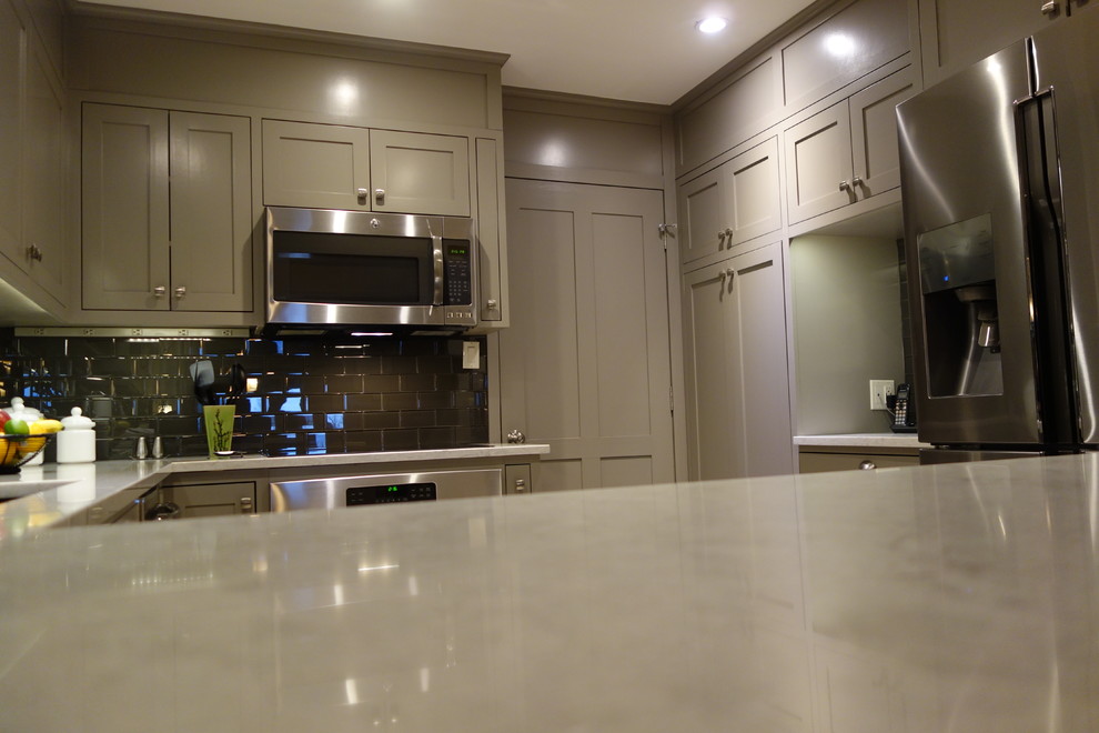 Example of a small transitional u-shaped ceramic tile home design design with an undermount sink, shaker cabinets, gray cabinets, quartz countertops, gray backsplash, glass tile backsplash, stainless steel appliances and a peninsula