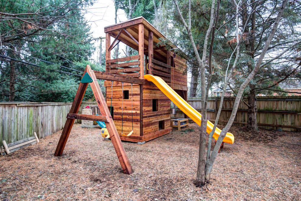 This is an example of an expansive country backyard outdoor sport court in Other with with outdoor playset and mulch.