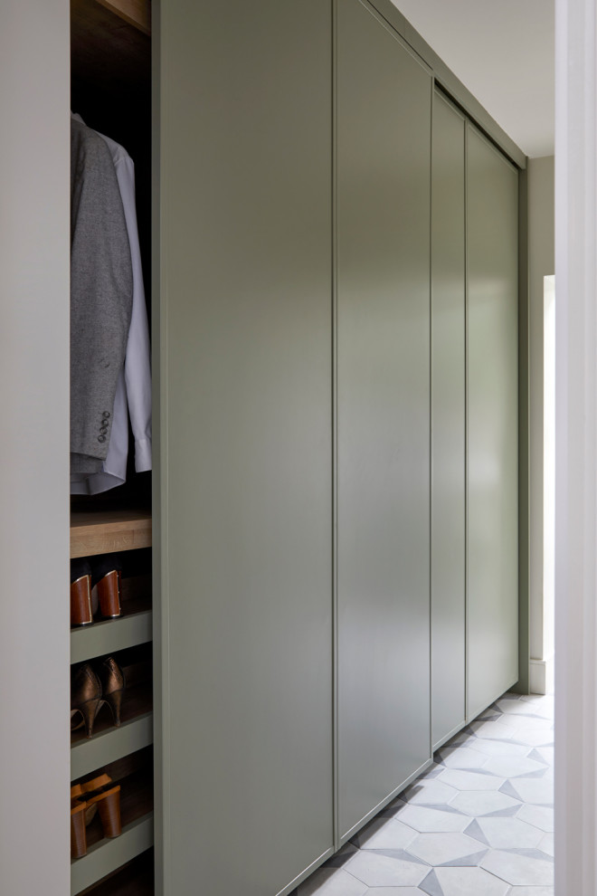 Modelo de armario y vestidor unisex de tamaño medio con a medida, puertas de armario verdes, suelo de baldosas de porcelana y suelo gris