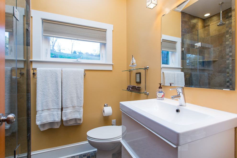 Example of a small transitional 3/4 brown tile and terra-cotta tile terra-cotta tile and brown floor alcove shower design in DC Metro with a two-piece toilet, yellow walls, flat-panel cabinets, white cabinets, an integrated sink and a hinged shower door