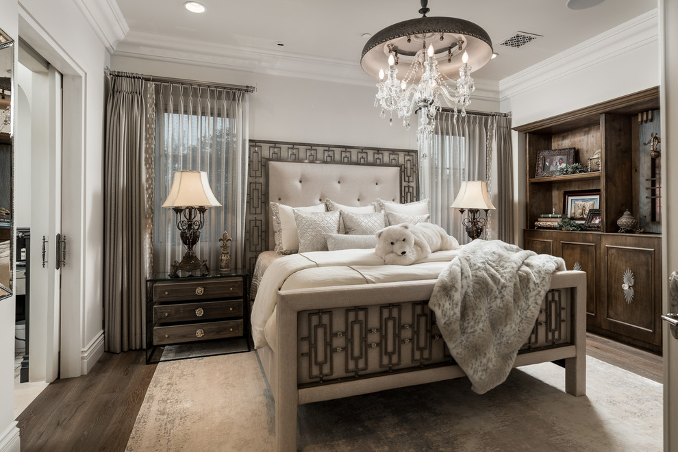 Inspiration for an expansive mediterranean master bedroom in Phoenix with white walls, dark hardwood floors, a two-sided fireplace, a stone fireplace surround and brown floor.