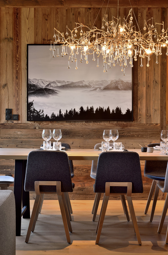 Immagine di una sala da pranzo minimal con parquet chiaro, travi a vista e pareti in legno