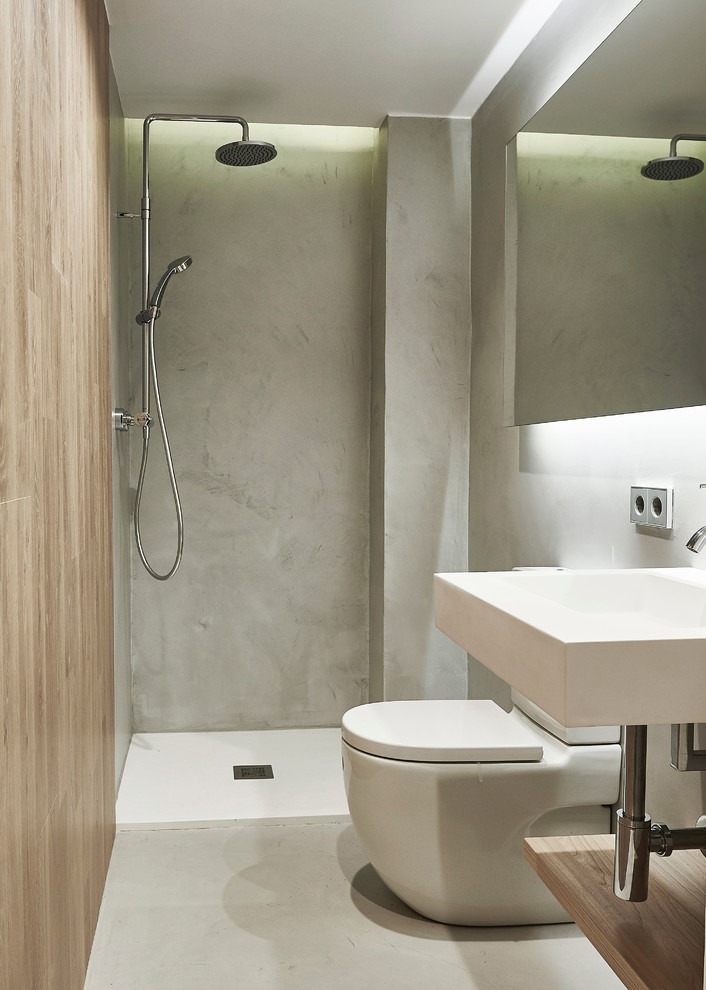 Photo of a small contemporary 3/4 bathroom in Other with an open shower, a two-piece toilet, grey walls, concrete floors and a wall-mount sink.