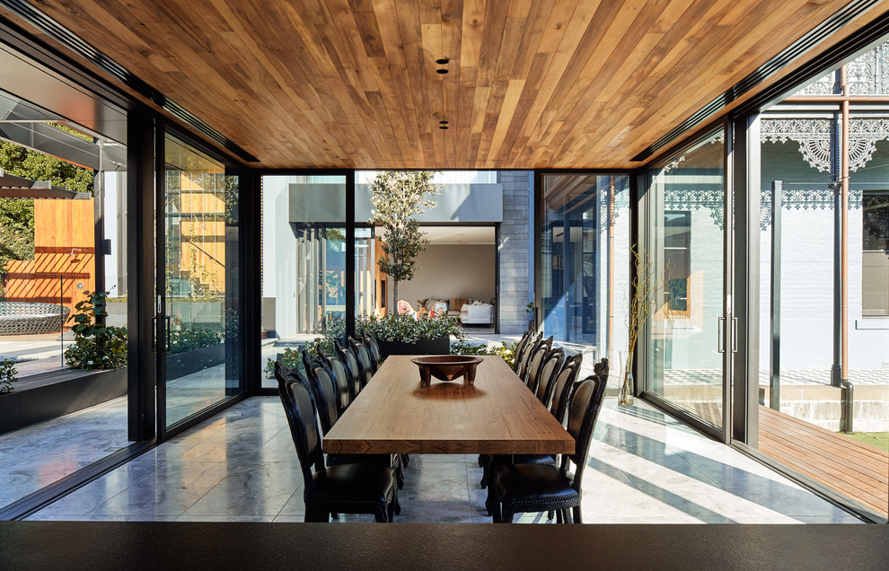 This is an example of a large contemporary kitchen/dining combo in Melbourne with limestone floors and grey floor.