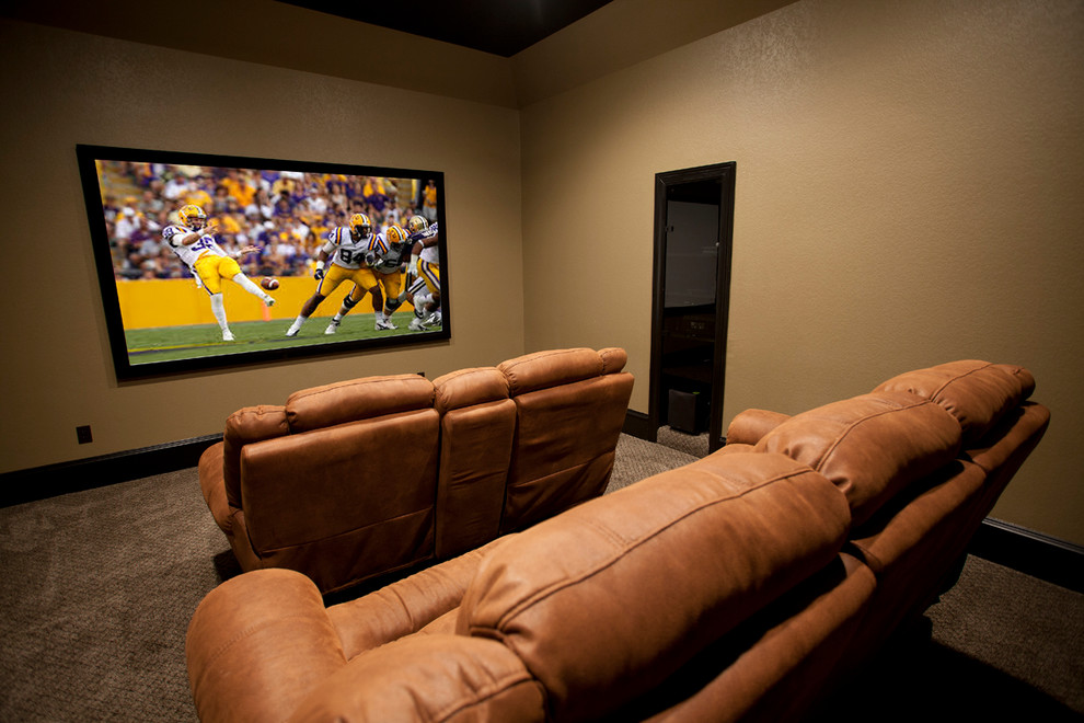 Design ideas for a large traditional enclosed home theatre in Austin with beige walls, carpet and a wall-mounted tv.