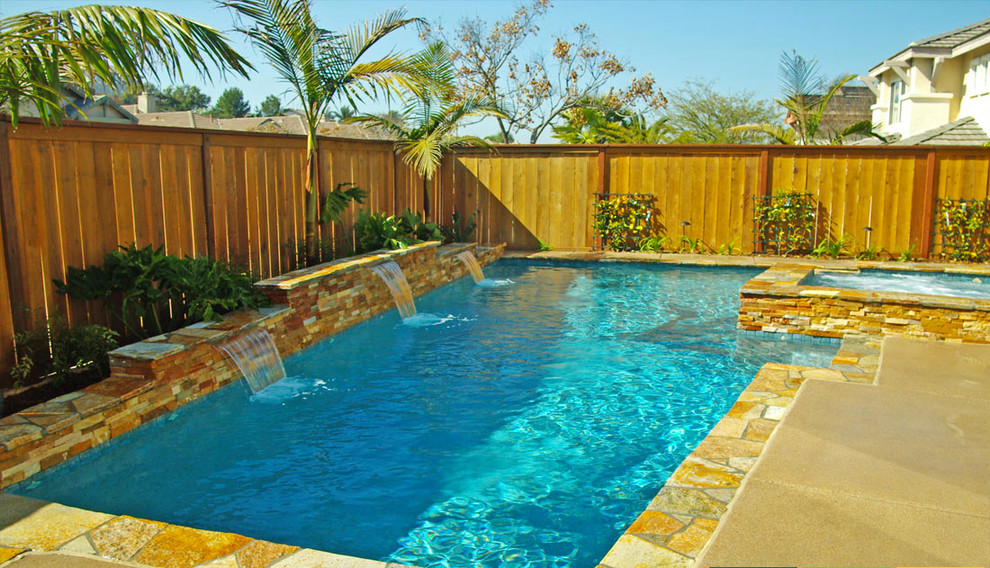 Photo of a mid-sized transitional backyard rectangular lap pool in Miami with a hot tub and concrete slab.