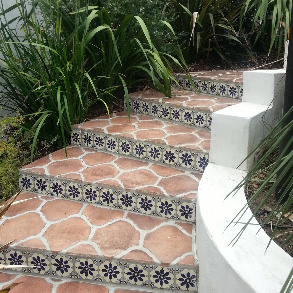 Inspiration for a mediterranean terracotta curved staircase in Los Angeles with tile risers.