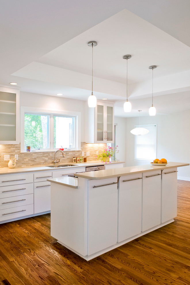 Example of a mid-sized transitional l-shaped medium tone wood floor eat-in kitchen design in Austin with flat-panel cabinets, white cabinets, solid surface countertops, beige backsplash, an island, a double-bowl sink, stone tile backsplash and stainless steel appliances