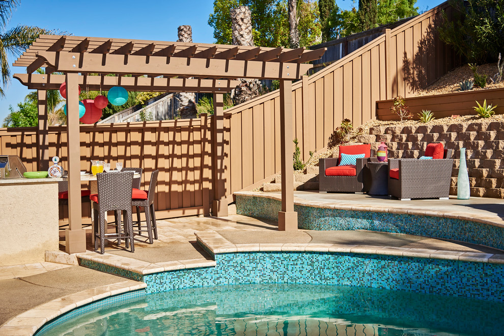 Inspiration for a mid-sized transitional backyard patio in San Diego with natural stone pavers and a pergola.