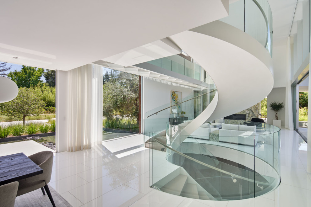 Large contemporary wood curved glass railing staircase in San Francisco with wood risers.