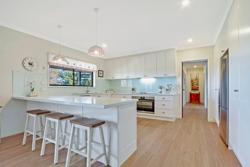 Clean White Shaker Kitchen with breakfast bar and overhead