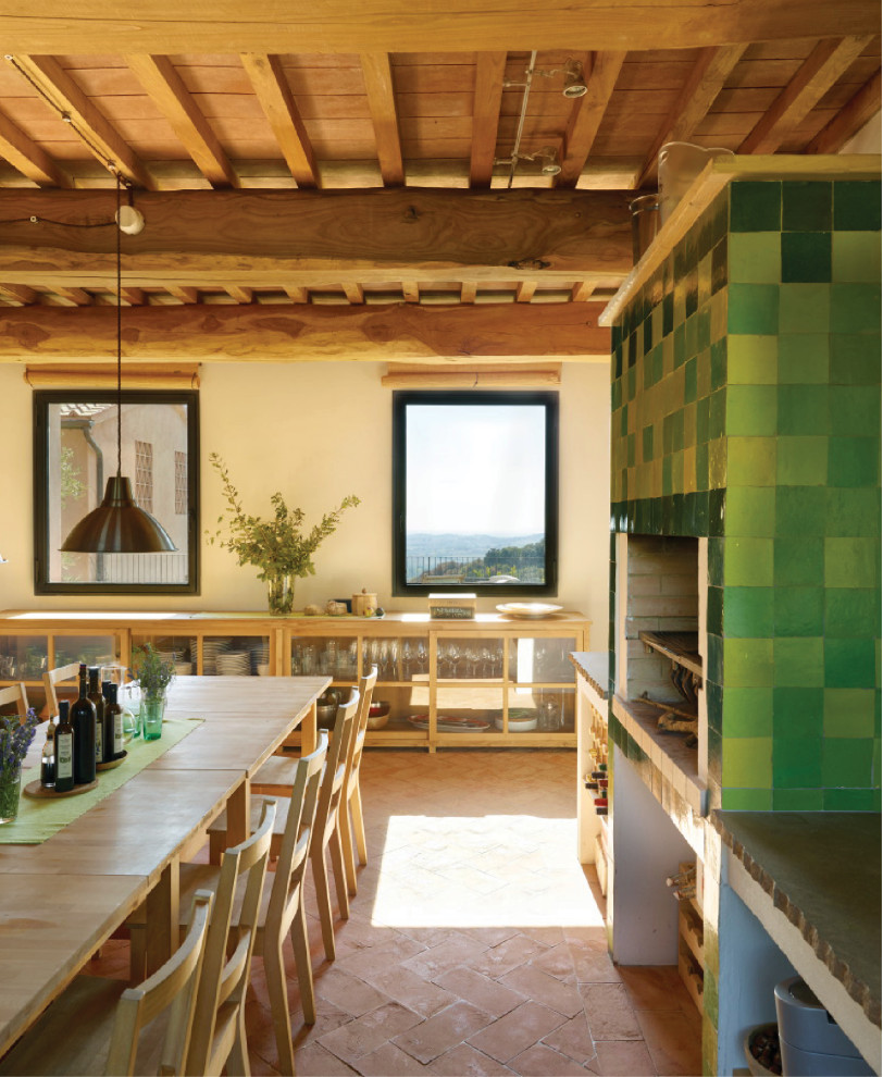 Bild på ett avskilt, stort lantligt grå linjärt grått kök, med en undermonterad diskho, öppna hyllor, skåp i ljust trä, bänkskiva i kalksten, grönt stänkskydd, stänkskydd i cementkakel, integrerade vitvaror, klinkergolv i terrakotta och rött golv