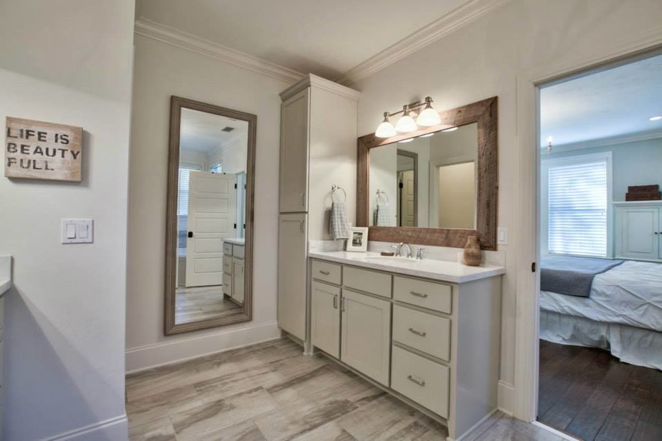 This is an example of a mid-sized beach style master bathroom in Atlanta with shaker cabinets, white cabinets, a drop-in tub, a corner shower, a two-piece toilet, stone tile, white walls, vinyl floors, an undermount sink and marble benchtops.