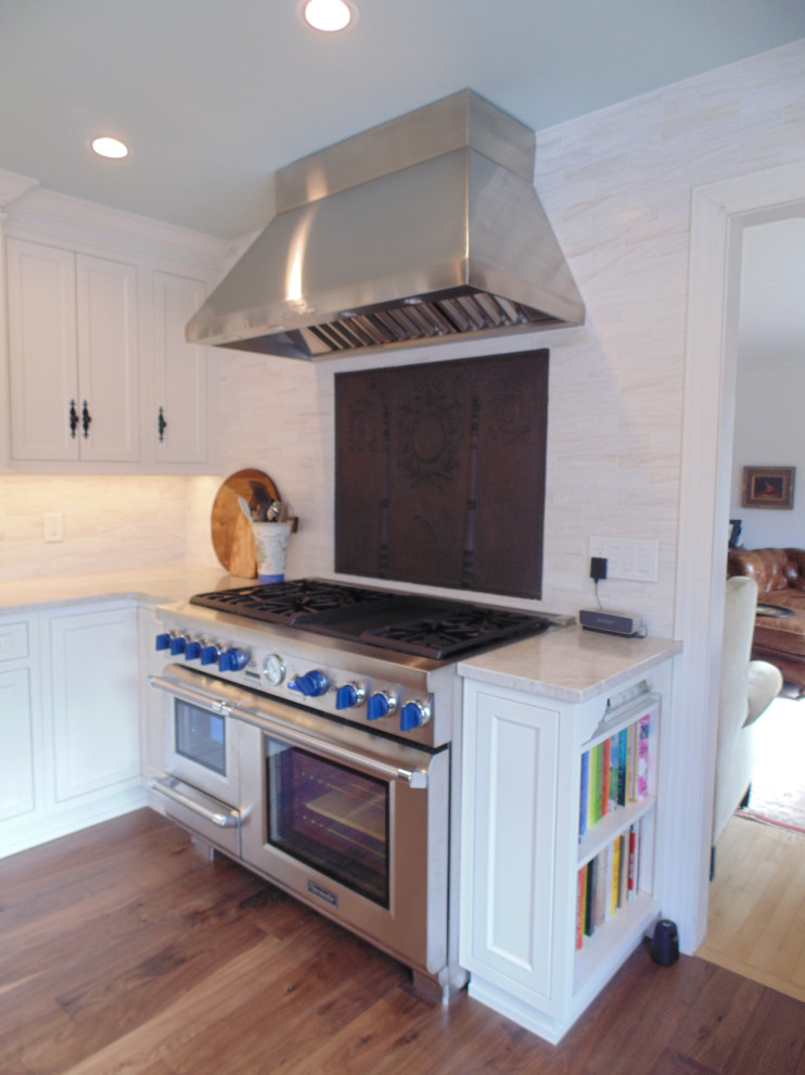 Large transitional u-shaped medium tone wood floor and brown floor eat-in kitchen photo with an undermount sink, recessed-panel cabinets, white cabinets, quartzite countertops, beige backsplash, subway tile backsplash, stainless steel appliances, an island and beige countertops