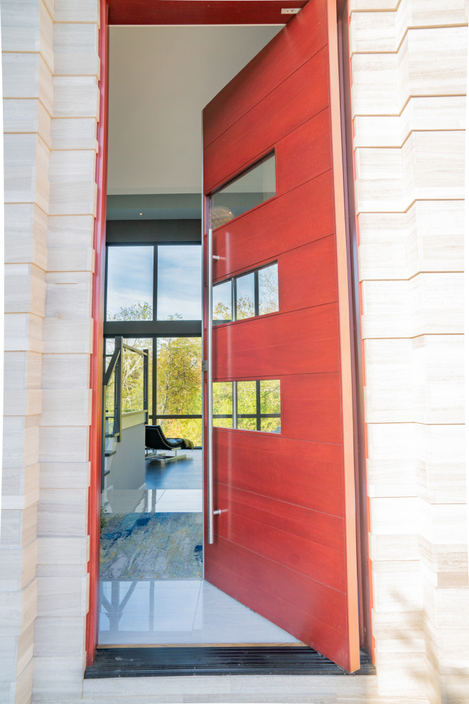 Foto på en mycket stor funkis ingång och ytterdörr, med en pivotdörr och en röd dörr