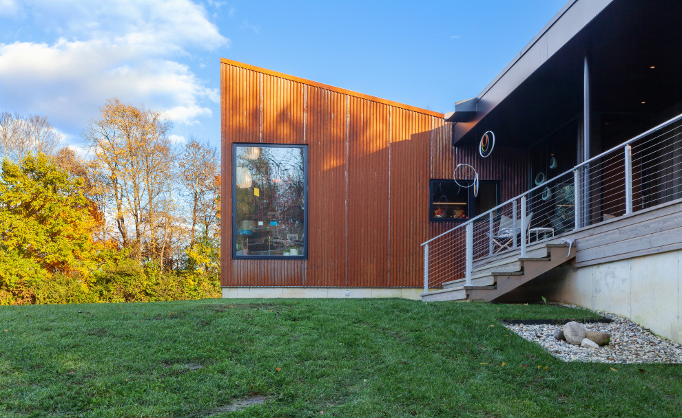 Idéer för ett mellanstort modernt oranget hus, med allt i ett plan, metallfasad, pulpettak och tak i metall