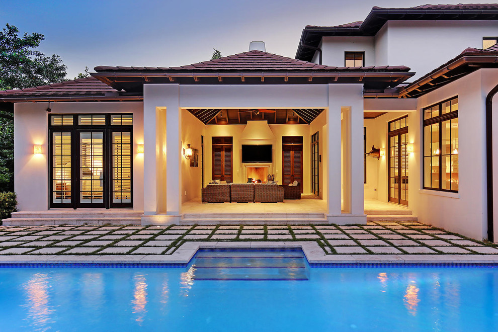 This is an example of a mid-sized traditional backyard rectangular lap pool in Tampa with concrete pavers.