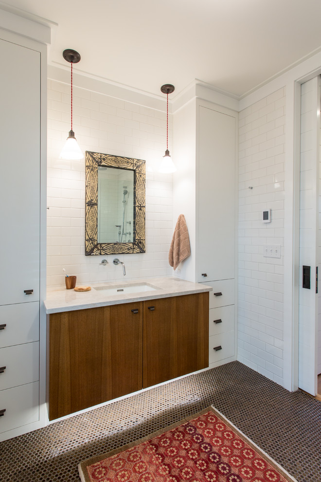 Inspiration for a country bathroom in New York with flat-panel cabinets, white tile, white walls, ceramic floors, an undermount sink, medium wood cabinets, subway tile and brown floor.