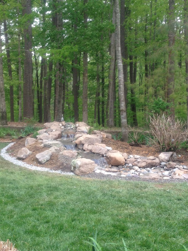 Design ideas for a mid-sized rustic partial sun backyard water fountain landscape.
