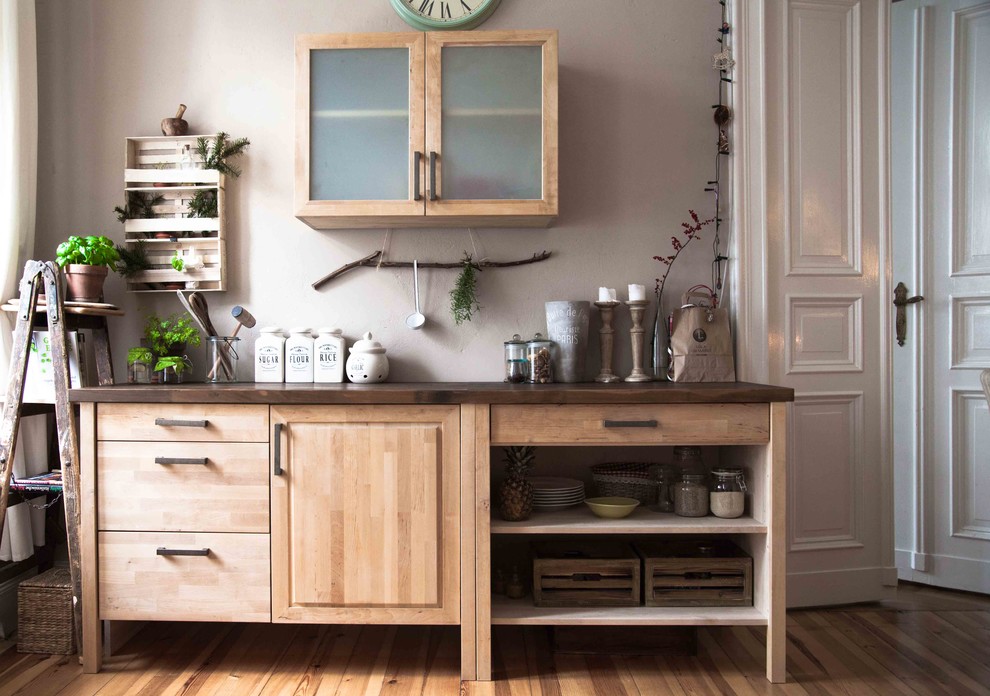 Inspiration for a small country separate kitchen in Berlin with medium wood cabinets, wood benchtops, medium hardwood floors and raised-panel cabinets.