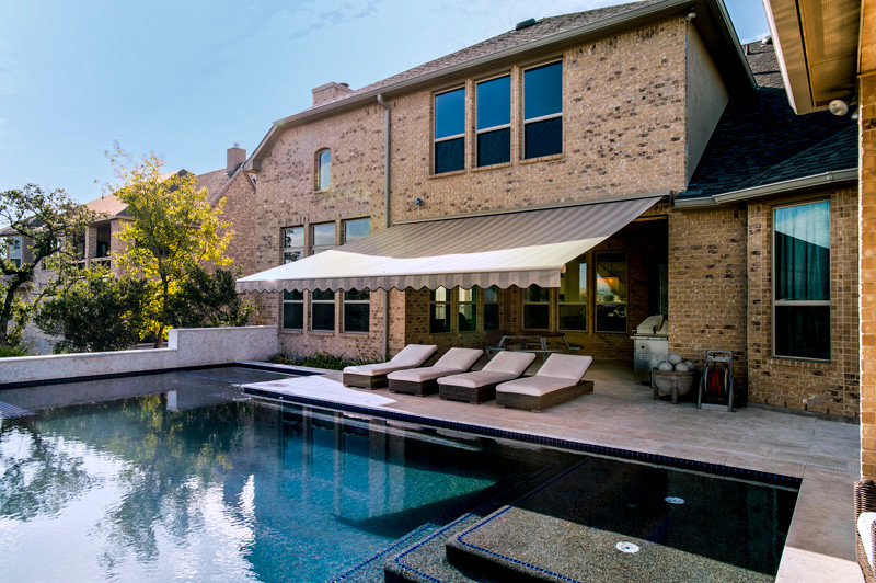 This is an example of a mid-sized traditional backyard custom-shaped lap pool in Orange County with concrete pavers.
