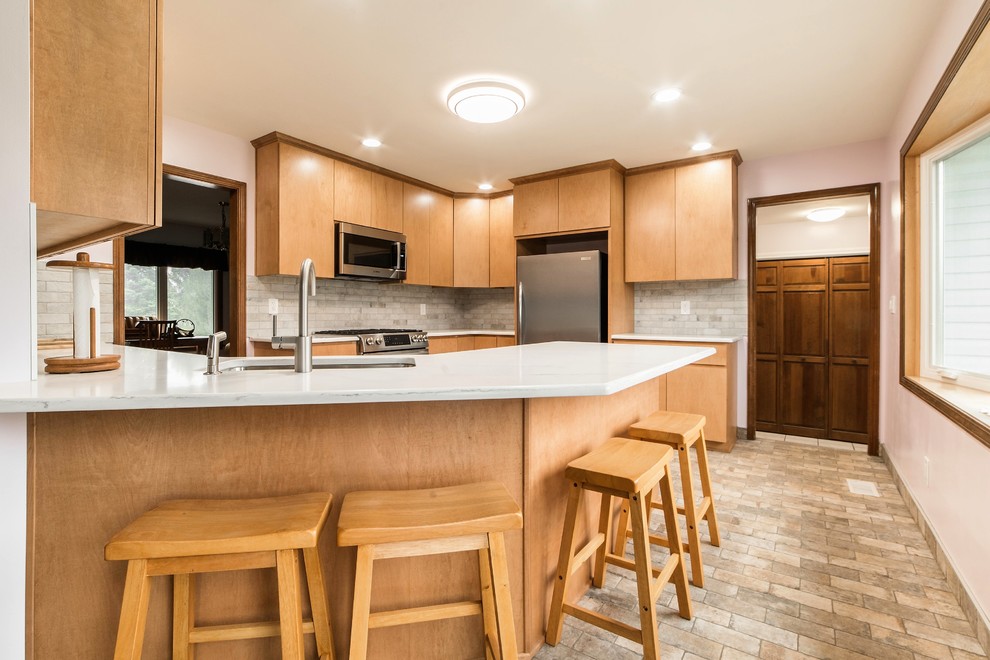 Eat-in kitchen - mid-sized transitional l-shaped ceramic tile and multicolored floor eat-in kitchen idea in Chicago with an undermount sink, flat-panel cabinets, light wood cabinets, quartz countertops, multicolored backsplash, ceramic backsplash, stainless steel appliances, a peninsula and multicolored countertops