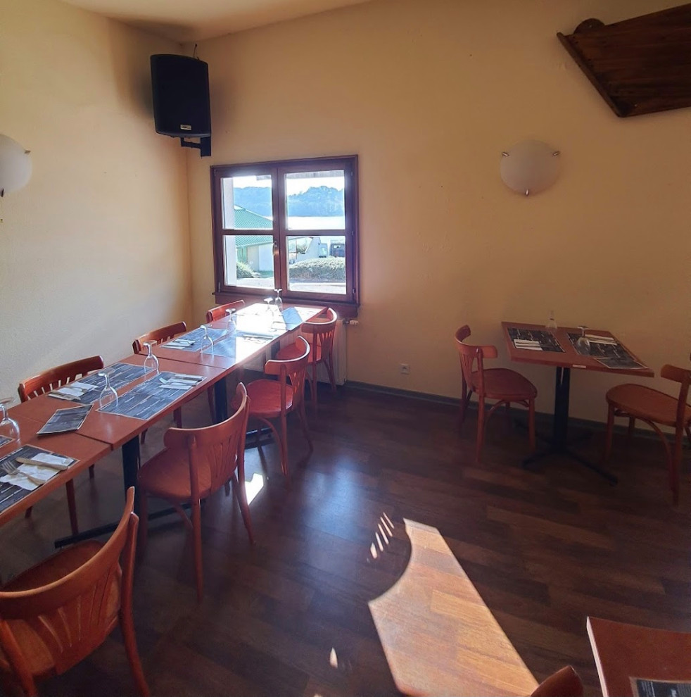 Exemple d'une grande salle à manger ouverte sur le salon industrielle en bois avec un mur noir, un sol en bois brun, aucune cheminée et un sol marron.