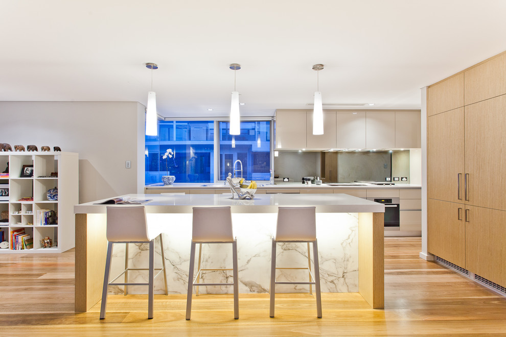 This is an example of a contemporary kitchen in Perth with flat-panel cabinets, white cabinets, stainless steel appliances, medium hardwood floors and with island.