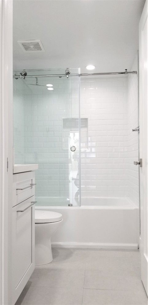 Design ideas for a small modern kids bathroom in Miami with shaker cabinets, white cabinets, a bidet, gray tile, grey walls, ceramic floors, an undermount sink, quartzite benchtops, grey floor, a sliding shower screen and white benchtops.