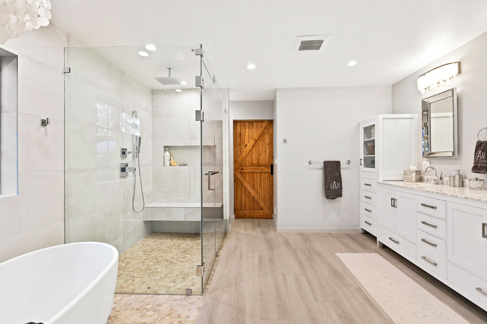 Design ideas for a large transitional master bathroom in Los Angeles with shaker cabinets, white cabinets, a freestanding tub, a corner shower, gray tile, porcelain tile, grey walls, porcelain floors, engineered quartz benchtops, grey floor, an undermount sink, a hinged shower door and beige benchtops.