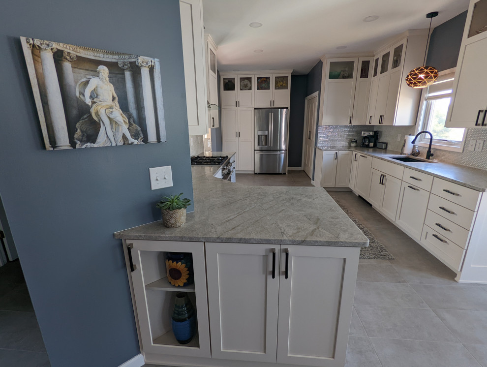 Large transitional u-shaped separate kitchen in Indianapolis with white cabinets, white splashback, a peninsula, grey benchtop, an undermount sink, shaker cabinets, granite benchtops, ceramic splashback, stainless steel appliances, ceramic floors and grey floor.