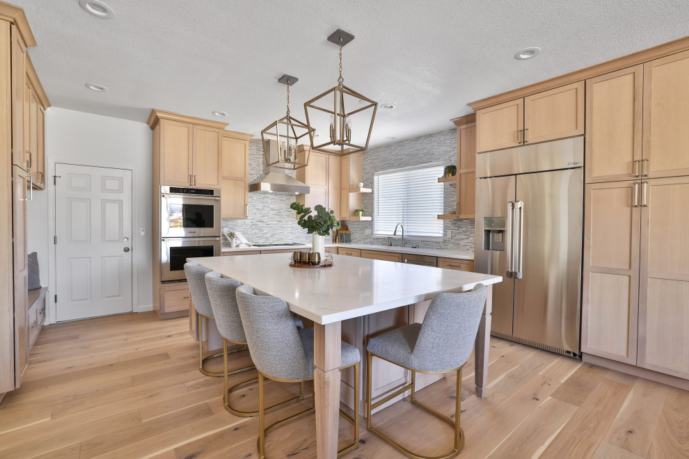 Example of a light wood floor kitchen design in San Francisco with an undermount sink, shaker cabinets, light wood cabinets, quartz countertops and an island