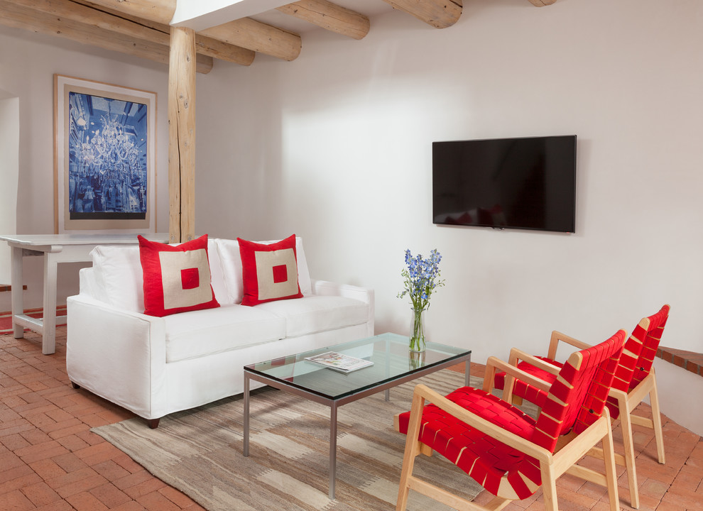 Inspiration for an open concept living room in Albuquerque with white walls, brick floors and a wall-mounted tv.