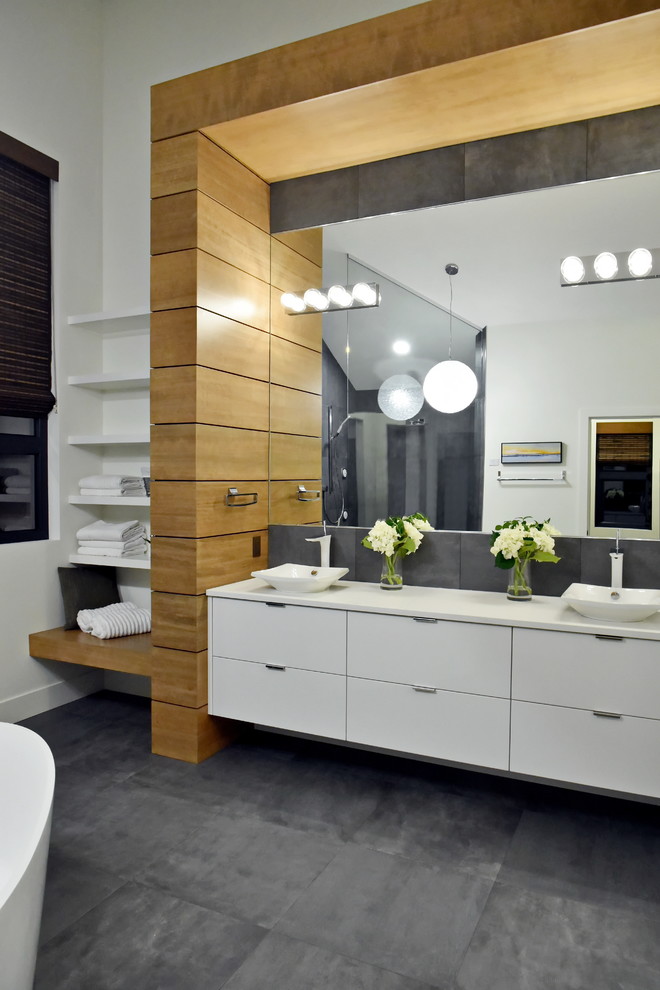 Design ideas for a large contemporary master bathroom in Edmonton with white walls, a freestanding tub, a vessel sink, flat-panel cabinets, white cabinets, a corner shower, engineered quartz benchtops and grey floor.
