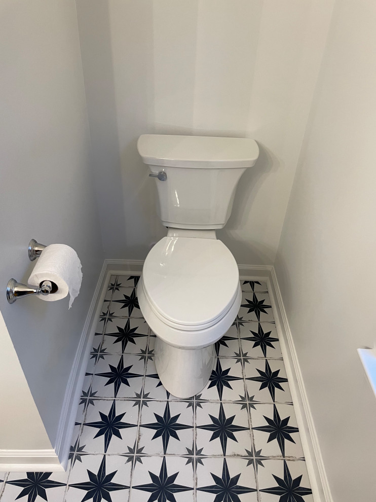 Inspiration for a modern cloakroom in Atlanta with shaker cabinets, blue cabinets, a one-piece toilet, blue tiles, ceramic tiles, white walls, ceramic flooring, a submerged sink, marble worktops, multi-coloured floors, yellow worktops, a freestanding vanity unit and a vaulted ceiling.