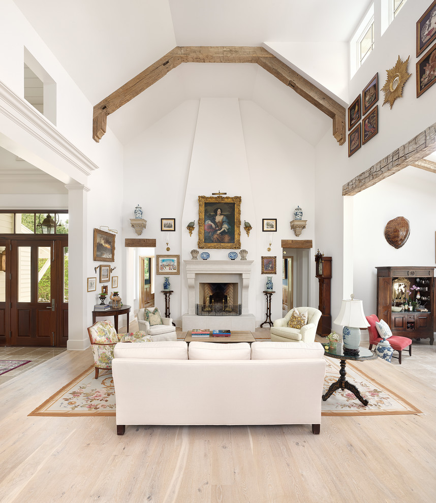 Inspiration for a traditional open concept living room in Charleston with white walls, light hardwood floors, a standard fireplace and beige floor.