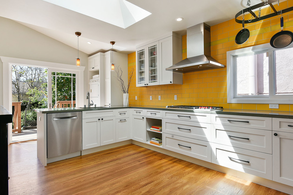 Design ideas for a mid-sized transitional u-shaped separate kitchen in San Francisco with an undermount sink, shaker cabinets, white cabinets, quartz benchtops, yellow splashback, ceramic splashback, stainless steel appliances, medium hardwood floors, a peninsula, brown floor and grey benchtop.