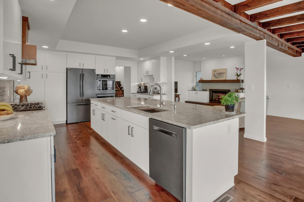 Mid-sized midcentury galley eat-in kitchen in Other with an undermount sink, flat-panel cabinets, white cabinets, granite benchtops, stainless steel appliances, with island, grey benchtop and exposed beam.
