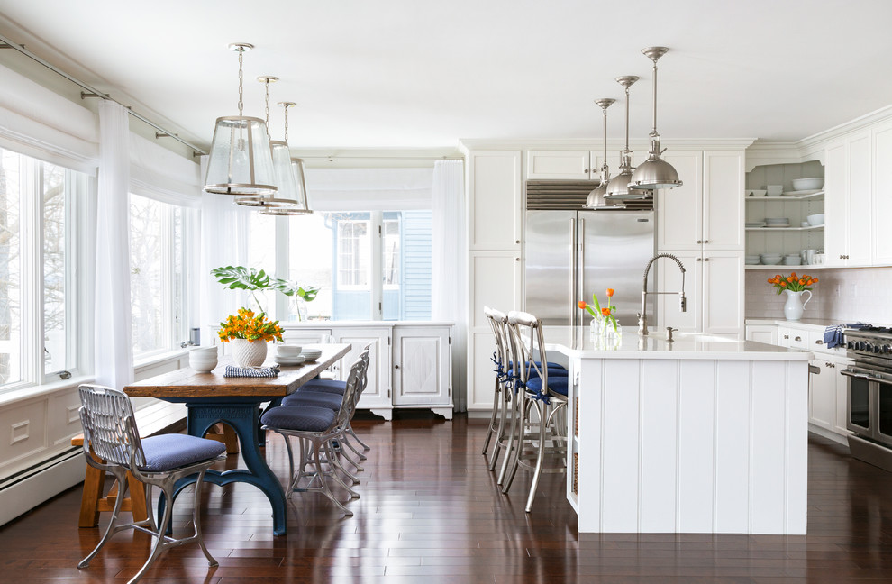 Design ideas for a large beach style eat-in kitchen in New York with shaker cabinets, white cabinets, stainless steel appliances, dark hardwood floors and with island.