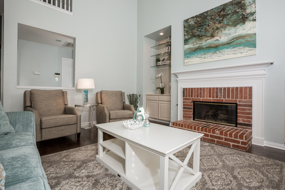 This is an example of a large transitional open concept family room in Dallas with grey walls, medium hardwood floors, a standard fireplace, a brick fireplace surround and a wall-mounted tv.
